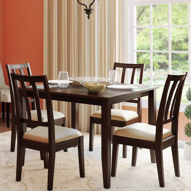 A dark brown set of chairs with a table 
