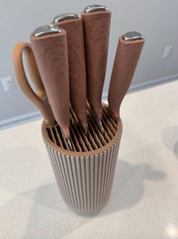 Knife acceptable   with woody  handles displayed successful  a matching vertical slotted holder connected  a room  countertop