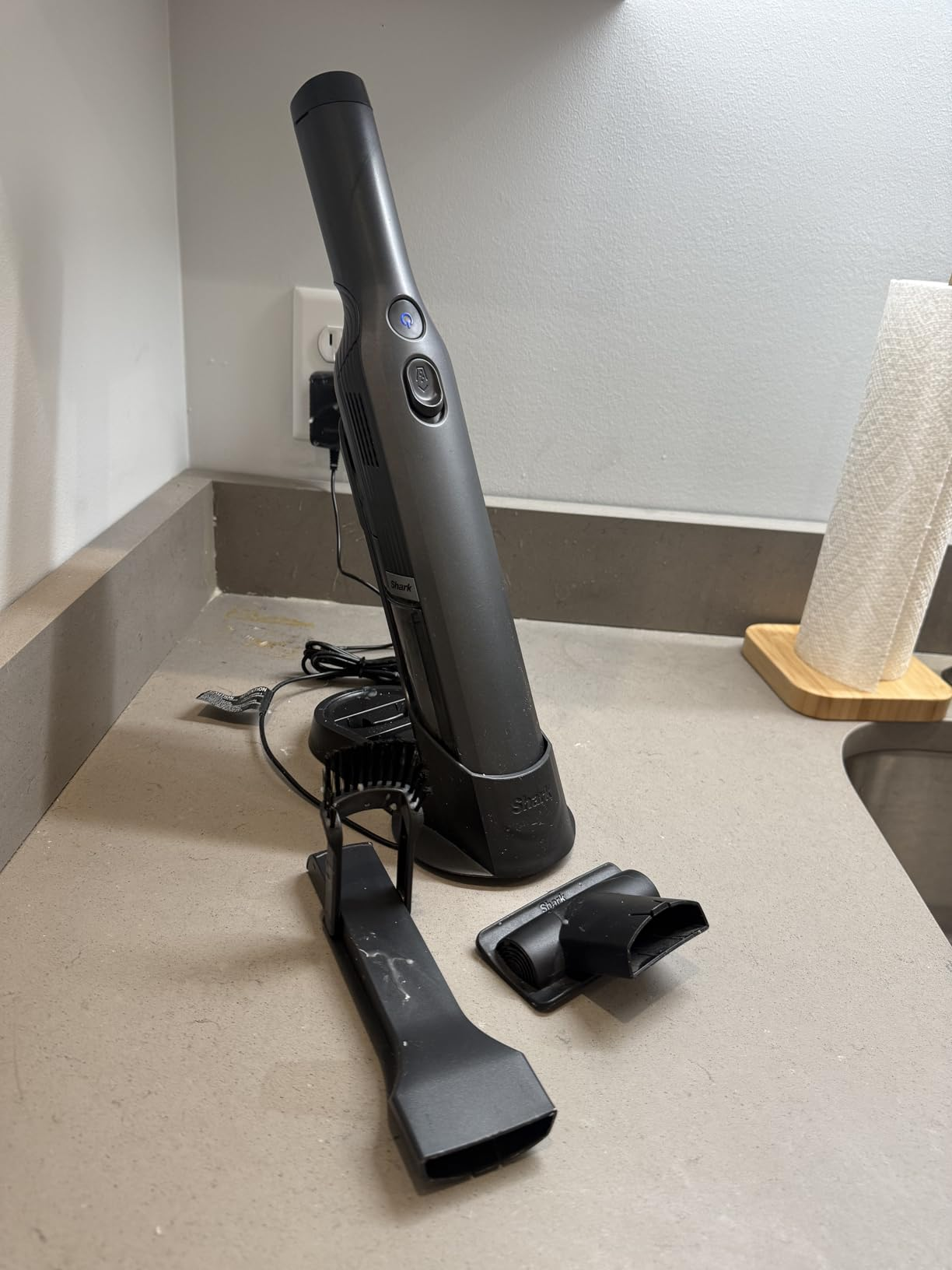 Cordless handheld vacuum connected  a countertop with attachments placed nearby, viewed successful  a room  setting