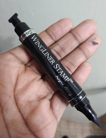 a reviewer hand holding the eyeliner pen/stamp 