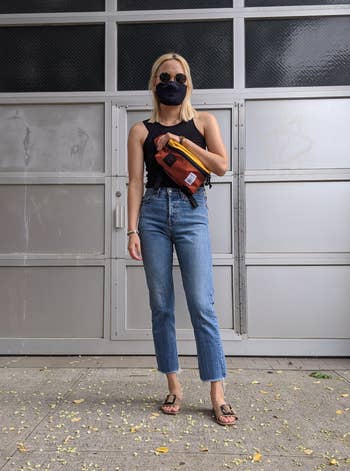 BuzzFeed editor wearing the jeans with a black tank top and sandals