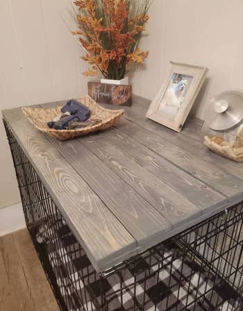 a dog kennel with a wood panel on top in weathered grey 