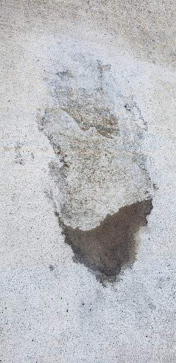 reviewer photo of the same oil stain and the area where the stain remover sat is much lighter