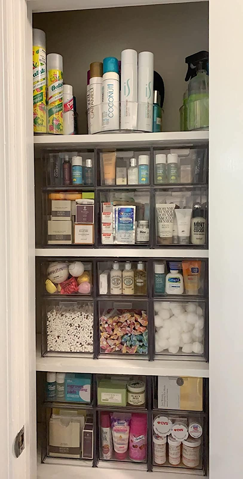 reviewers closet full of the stackable drawers holding a variety of cosmetics, medicines, and other bathroom essentials