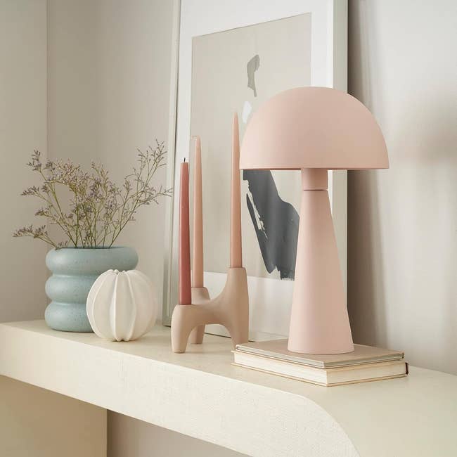 Modern decor with abstract art, a mushroom-style lamp, and small decorative items on a shelf for home styling inspiration