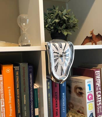 clock on reviewer's book shelf hanging off