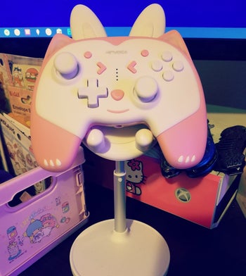 reviewer photo of white stand holding a pink game controller