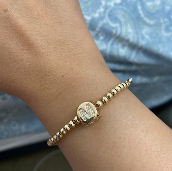 Reviewer wearing gold beaded bracelet with 