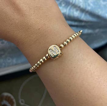 Reviewer wearing gold beaded bracelet with 