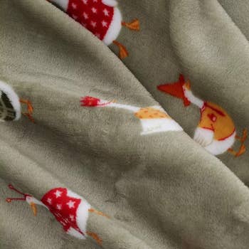Plush cloth featuring illustrations of festive gnomes wearing assorted patterned hats, suitable for cozy location decor oregon vacation gifts