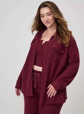 Person wearing a textured, button-down garment and matching pants set, posing confidently