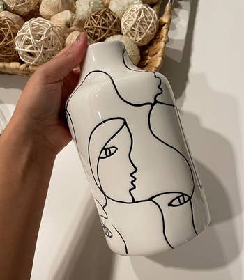 reviewer holding the white and black vase