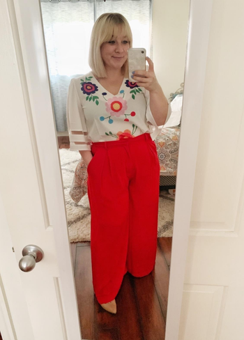 reviewer in red wide leg pants