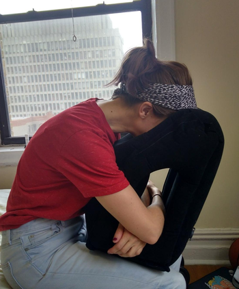 reviewer using the black inflatable pillow