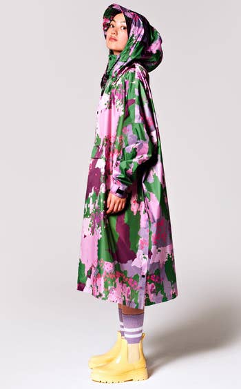 model wearing a long poncho in spring camo pattern with green and purple colors