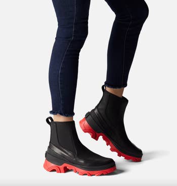 model wearing black and red Sorel rain booties