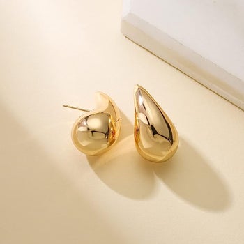 a pair of gold tear drop shaped earrings