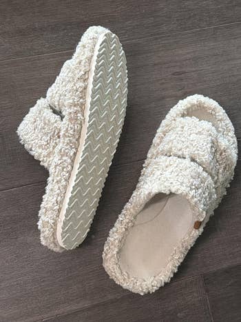 Textured slip-on slippers with soft, fuzzy cloth  and durable soles connected  a woody  floor