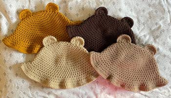 Four teddy-inspired crochet bucket hats in different shades of brown