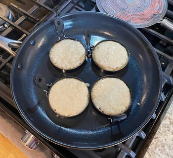 four small pancakes cooking in molds 