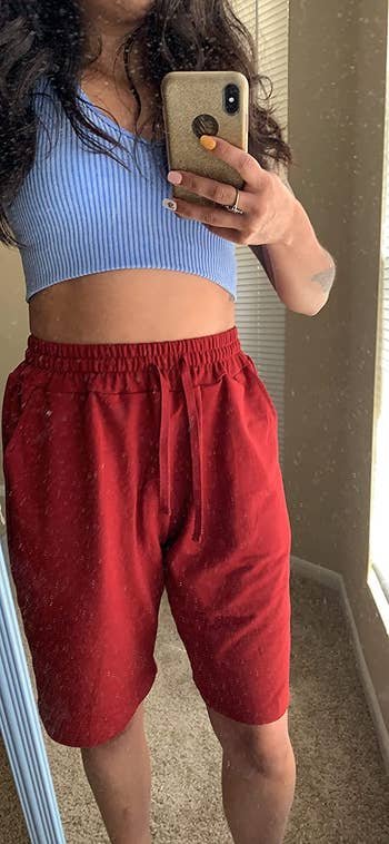 a reviewer wearing the shorts in burgundy