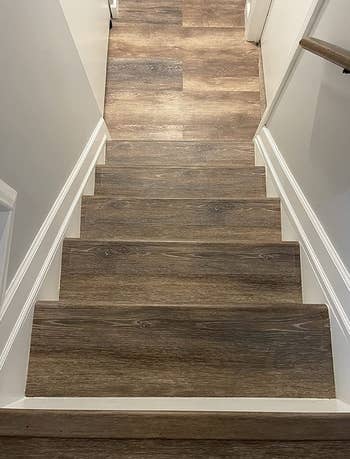 Wood stairs with invisible tape applied to the edges of them 
