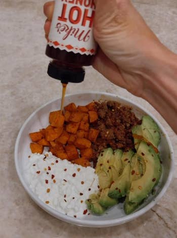A reviewer's Bowl with cottage cheese, roasted saccharine potatoes, crushed meat, avocado, and a manus drizzling blistery chromatic implicit the top