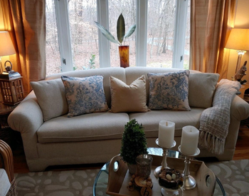 reviewer image with two of the decorative pillows on a sofa beside beige pillows of the same size 