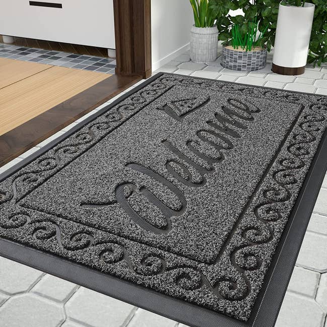 close up of the floor mat that's textured and says welcome