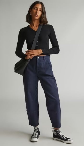 model wearing the navy pants with a black top and sneakers