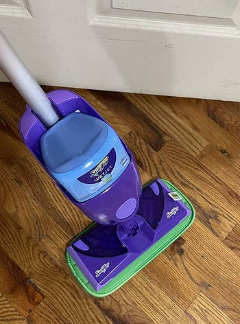 a reviewer photo of a swiffer wet jet with one of the reusable mop pads attached 