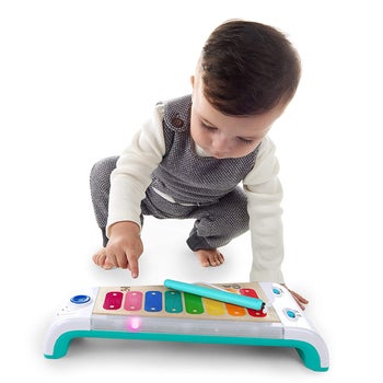 A child playing with the wooden xylophone