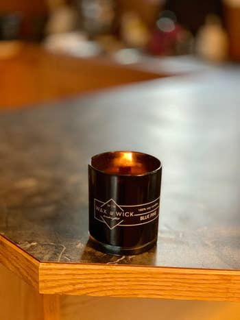 reviewer photo of a black lit wood wick candle in the scent 