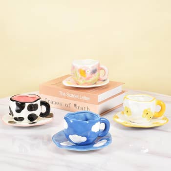 the same size and shape mugs in a cow, cloud, and two floral patterns 