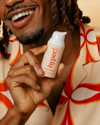 model smiling holding bottle of the serum