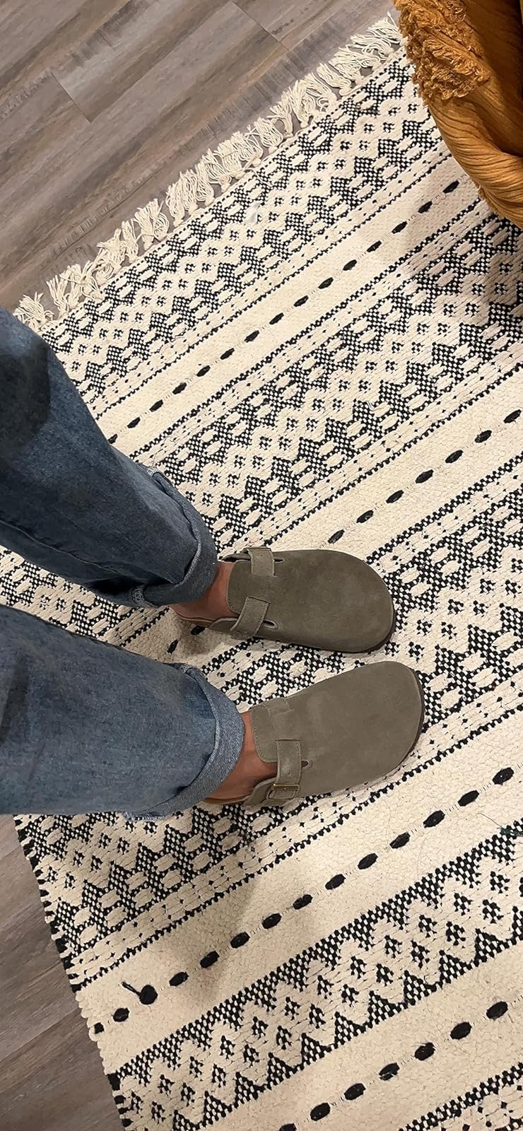 a reviewer wearing the shoes in dark green with jeans 