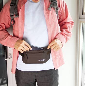Person wearing a pinkish  shirt, placing an point  successful  a achromatic  waist container  with a logo, showcasing a applicable  accessory for shopping