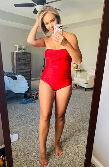 a reviewer wearing the swimsuit strapless and in red