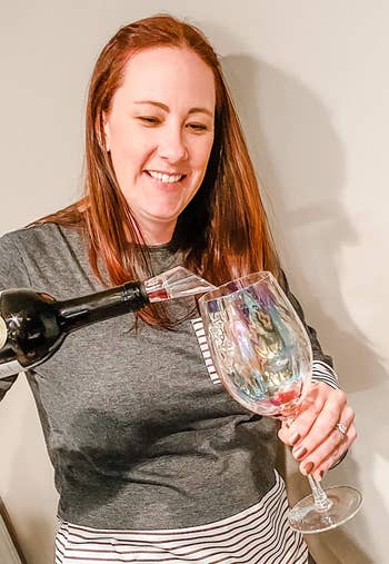 reviewer pouring a glass of wine with the aerator on the bottle 