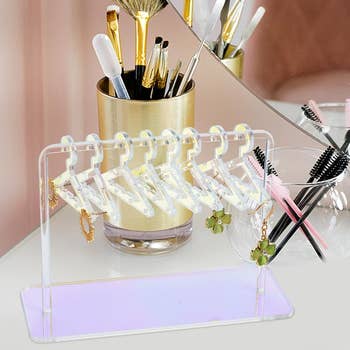 Acrylic earring organizer standing on a dresser with various earrings