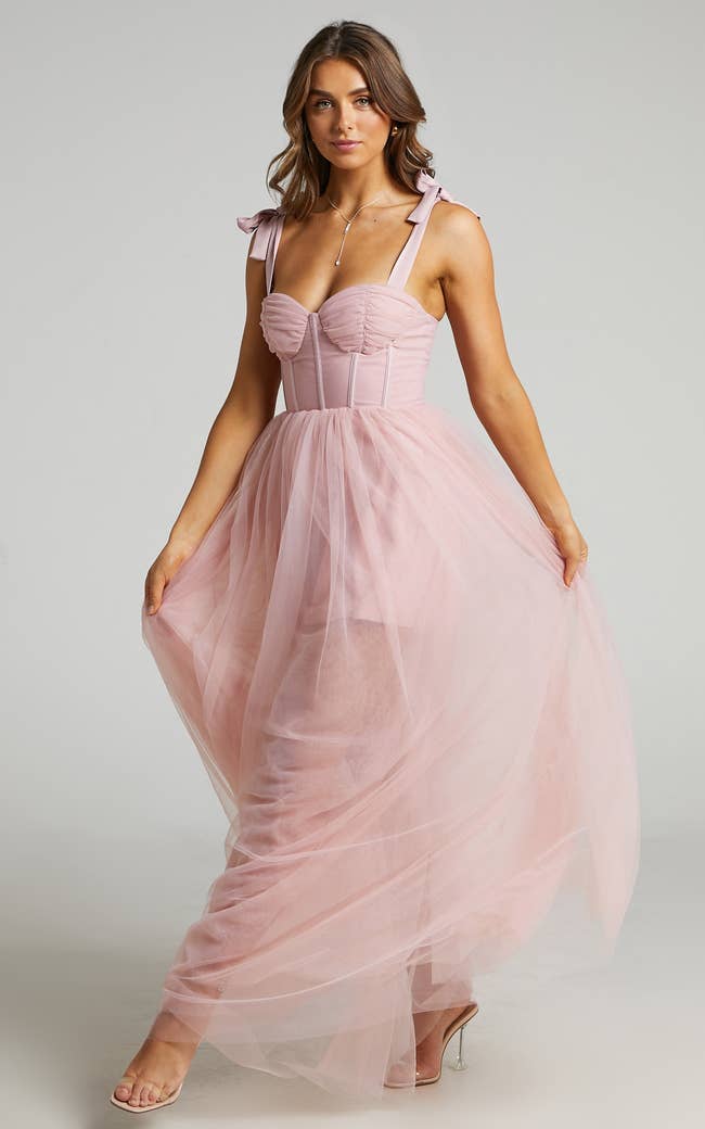 a model in a pink tulle dress with a bustier top