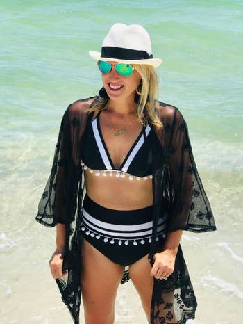 reviewer wearing two piece suit with black lace swim cover, sunglasses, and a hat