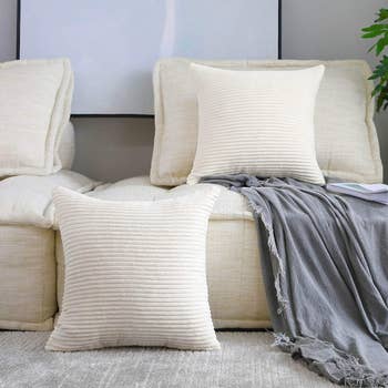 two white throw pillows made of soft corduroy