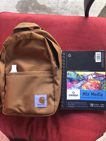 reviewer photo of yellow Carhartt mini backpack