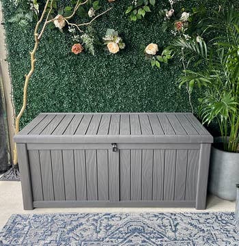 a reviewer photo of a rectangular storage box on a patio 