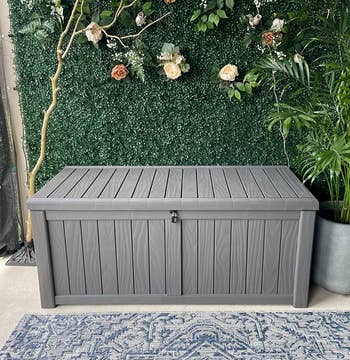 a reviewer photo of a rectangular storage box on a patio 