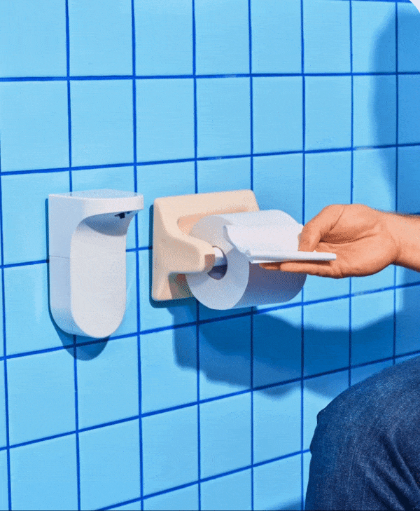 a model placing a piece of toilet paper under the touchless dispenser