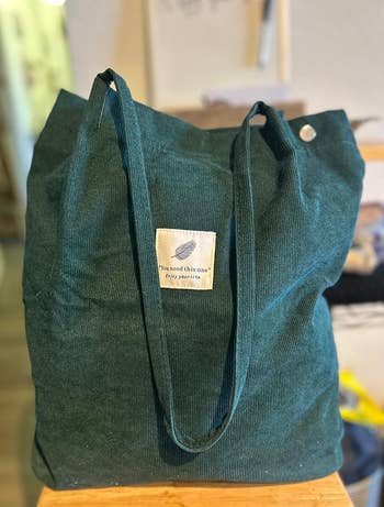 Social media trends Viral content Trending hashtags Social media updates Trending memes and videos Green tote bag with long handles, featuring a fabric label with text: 
