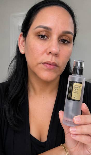 Person holding a skincare vessel  labeled 