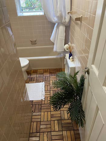 the same bathroom with teak tiles on bathroom floor